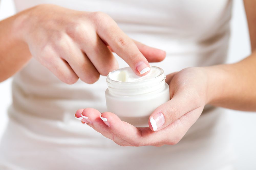 Woman scooping cream out of tub